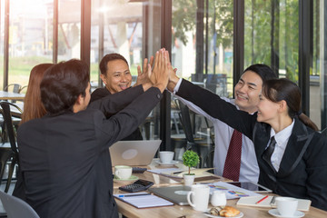 Successful business team making a high five in outdoor meeting.