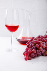 Wine Pink and Grape bunch. Alcoholic drink in a glass glass on a light background.Copy space for Text. selective focus.