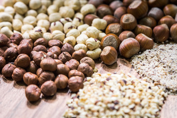 hazelnuts of different types on a wooden plate. healthy foods. soft focus