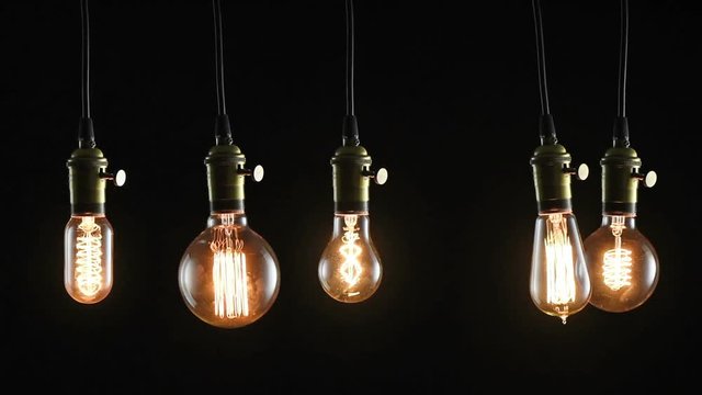 Swinging flickering vintage light bulbs In the dark