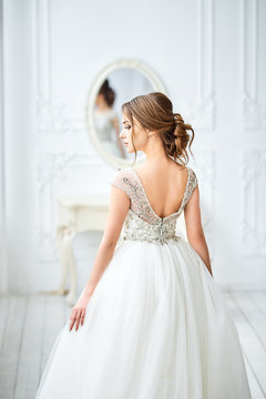Wedding, people, fashion and beauty concept - bride in wedding dress. Back view.