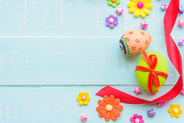 Happy easter! Colorful of Easter eggs with red ribbon and colorful of paper flower and paper star on pastel color bright green and white wooden background.