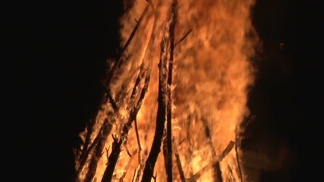 night fire sparks flying in the dark night sky, big night bonfire in a clearing in the forest