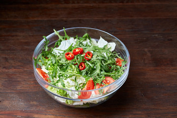 Dietary mixed salad in glass sultana on vintage wooden background, selective focus