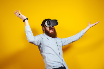 Cheerful funny bearded hipster man in casual having experience with VR glasses, goggles 3d view. Amazed bearded man with Virtual Reality gogles.