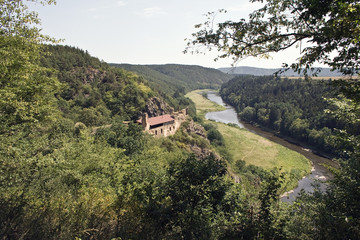 Obraz premium Building built on mountain by river.