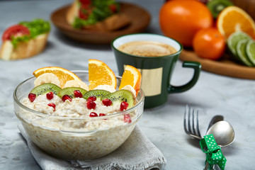 Breakfast still life with oatmeal porridge, fruits and coffee cup, top view, selective focus, shallow depth of field.