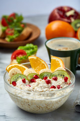 Breakfast still life with oatmeal porridge, fruits and coffee cup, top view, selective focus, shallow depth of field.