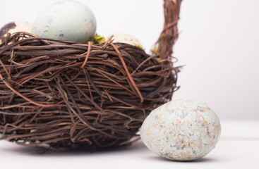 Easter composition with quail eggs in basket on a wooden backround. Top view. Holiday card.