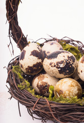 Obraz premium Easter composition with quail eggs in basket on a wooden backround. Top view. Holiday card.