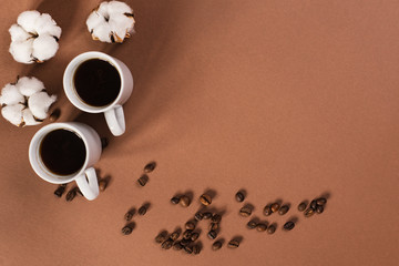 Two cups of coffee in the left corner of brown background. Morning conceptual photography. 