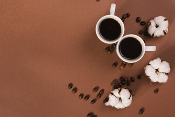 Two cups of coffee with cotton flowers. Top view.