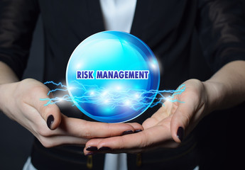 In the hands of a businessman, a neon circle with the inscription:RISK MANAGEMENT