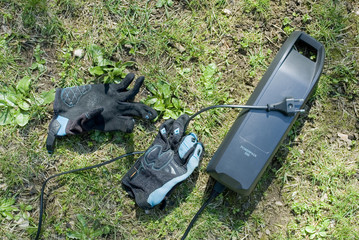 battery of electric bicycle, ebike, e-bike, charged with the current, inserted in the bike, helps to ride in city or uphill in mountains with a mtb, fun, sports, grass, Italy