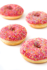 Obraz na płótnie Canvas Pink frosted donut with colorful sprinkles isolated on white background