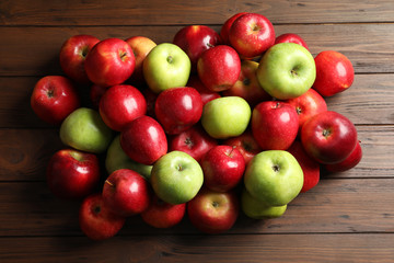 Fresh red and green apples on wooden background, top view