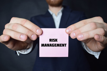 A businessman shows an inscription:RISK MANAGEMENT