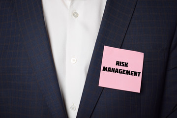 Businessman shows business card with the inscription:RISK MANAGEMENT