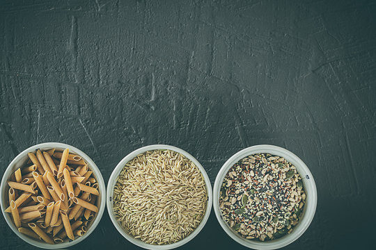 Brown Rice Grains, Seeds And Whole Grain Pasta In A Bowl. Healthy Food. Space For Writing