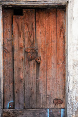 Vintage wooden door with rusty padlock
