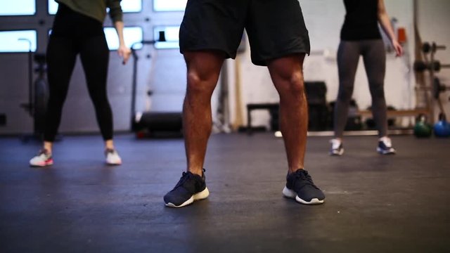 Closeup of a group of fit people working out with dumbbells together during an exercise class at a gym
