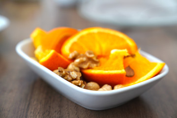 Sliced orange and nuts together in a bowl