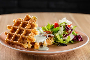 Savory Belgian waffles with cheese sauce and salad