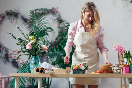 Image of blonde florist making bouquet of marshmallows, flowers