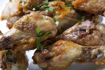 Close up of fresh Grilled chicken drumsticks with parsley leaves on plate