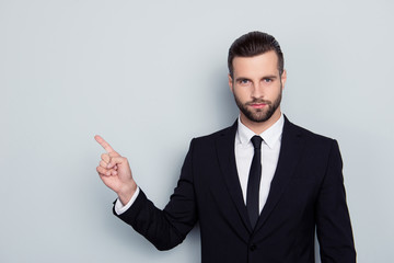 Portrait of authoritative strict manful bossy serious angry confident focused expert assistant wearing white shirt black tie pointing on empty blank copy space copyspace isolated on gray background