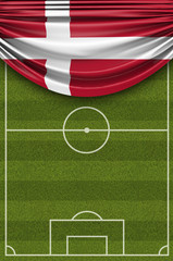 Fototapeta premium Denmark country flag draped over a football soccer pitch. 3D Rendering