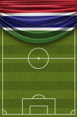 Fototapeta premium Gambia country flag draped over a football soccer pitch. 3D Rendering