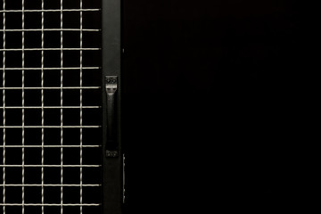 Black door with handle and metal grit on black background