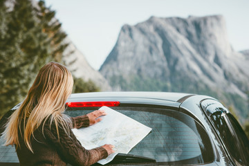 Woman with map planning route traveling by rental car road trip with map in Norway Travel Lifestyle concept adventure weekend vacations outdoor mountains on background