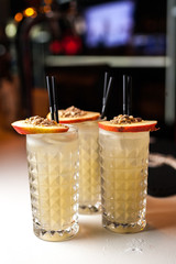 Group orange cocktails with apple and cinamon on the white bar