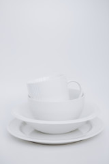 white utensils three plates cup white background vertical frame