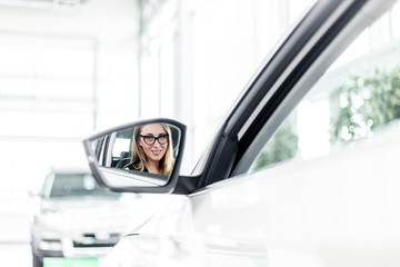 Reflection of attractive girls in a car side mirror