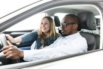 African man teaches girl to drive a car
