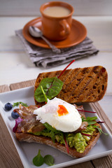 Egg, bacon, smashed white bean and avocado on toast. Sandwich