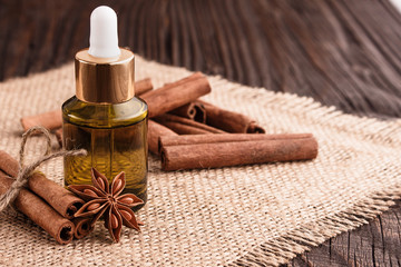 Cinnamon essential oil on a wooden background