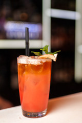 Colorful orange cocktail with mint in bar