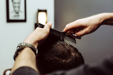 Male Barber shears scissors stylish man in the Barber shop closeup, concept retro style 70s