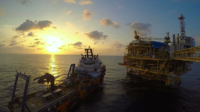 offshore timelapse sunset day to night with standby vessel near central processing platform