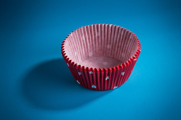 rote Backf&ouml;rmchen f&uuml;r Muffins aus Papier blauer Hintergrund