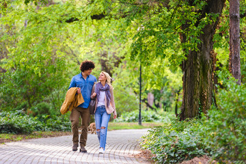 Obraz premium Young cheerful couple walking in the park