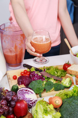 hand holding smoothies in glass at kitchen