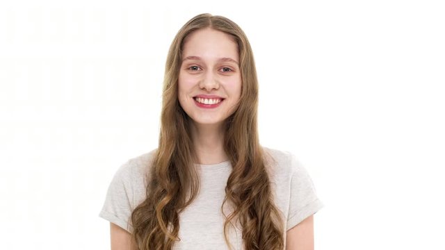 Portrait of teenage girl 17y having natural beauty wearing t-shirt and smiling on camera with perfect teeth, isolated over white background closeup. Concept of emotions