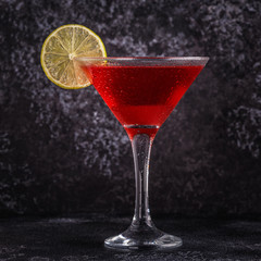 Glass of cosmopolitan cocktail decorated with lime