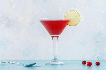 Glass of cosmopolitan cocktail decorated with lime