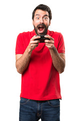 Happy handsome young man playing videogames over isolated white background